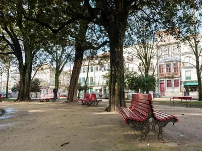 a group of park benches in a park with trees at Cozy Getaway in Porto with Balcony in Porto
