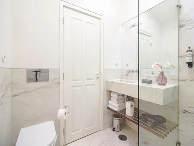 a bathroom with a toilet and a sink and a shower at City-center apartment with modern comforts in Porto