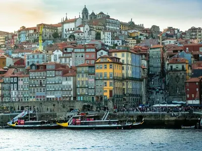 a group of boats in the water in front of a city at Cozy Porto studio with balcony in Porto