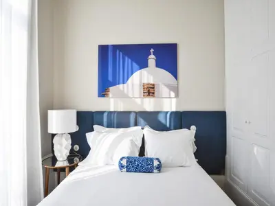 a bed with a blue headboard and white pillows at Modern and cozy apartment in Porto in Porto