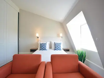 a bedroom with a bed and two orange chairs at Modern apartment in Porto's Vibrant Heart in Porto