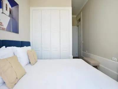 a bedroom with a large white bed with white pillows at Modern apartment in Porto's Vibrant Heart in Porto