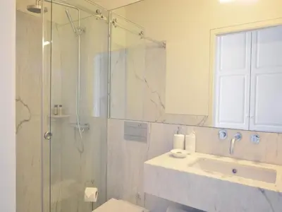 a bathroom with a glass shower and a sink at Modern apartment in Porto's Vibrant Heart in Porto