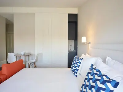 a bedroom with a white bed with blue and white pillows at Modern apartment in Porto's Vibrant Heart in Porto