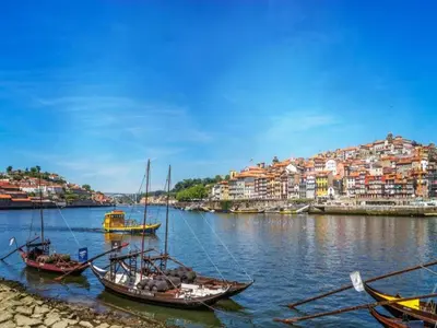 a group of boats in the water with a city at Heart of Porto Cozy Escape in Porto