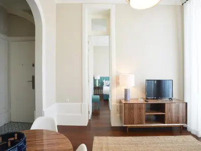 a living room with a tv and a table at Central City Escape with Balcony in Porto