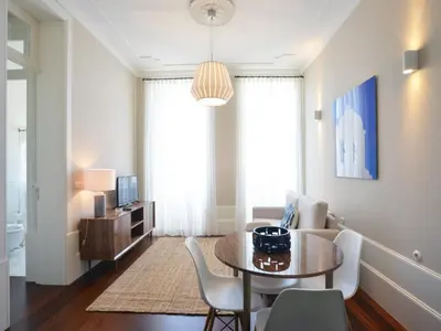 a living room with a table and chairs at Central City Escape with Balcony in Porto
