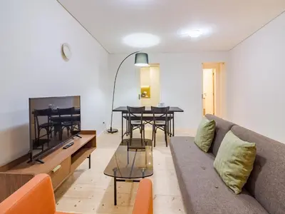 a living room with a couch and a table at 1-bedroom apartment in Porto's heart in Porto