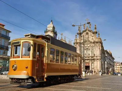 a yellow trolley car on a city street at 1-bedroom apartment in Porto's heart in Porto