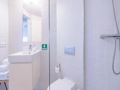 a bathroom with a toilet and a sink and a shower at Spacious 2-Bedroom Retreat in Porto in Porto