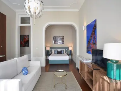 a living room with a white couch and a bed at Charming Central Porto Apartment in Porto
