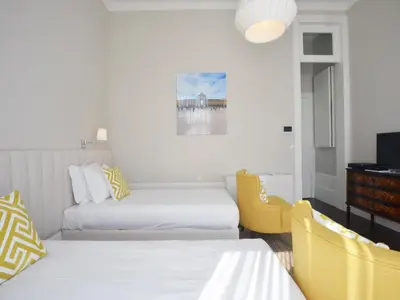 a hotel room with two beds and a tv at Cozy and modern apartment in Porto in Porto