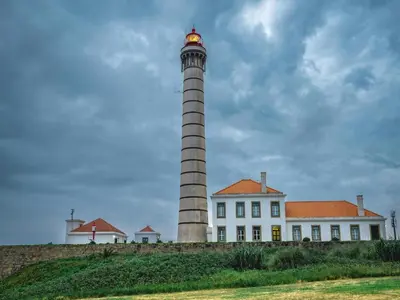 a lighthouse in front of a white building at Cozy and modern apartment in Porto in Porto