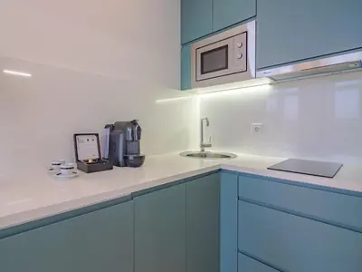 a kitchen with blue cabinets and a sink and a microwave at Charming studio, ideal for smaller groups in Porto