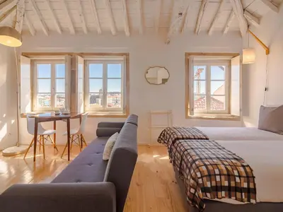 a bedroom with two beds and a couch and a table at Cozy Porto studio perfect location & comfort in Porto