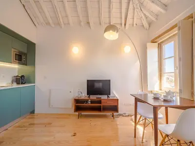 a living room with a table and a television at Cozy Porto studio perfect location & comfort in Porto