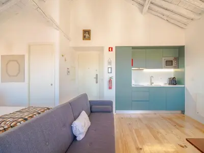 a living room with a couch and a kitchen at Cozy Porto studio perfect location & comfort in Porto