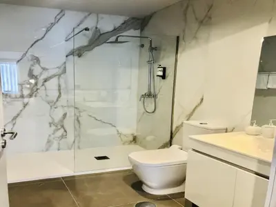 a bathroom with a shower and a toilet and a sink at Apartment near São Bento train station in Porto
