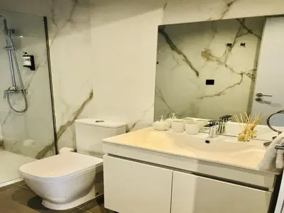 a white bathroom with a toilet and a sink at Apartment near São Bento train station in Porto