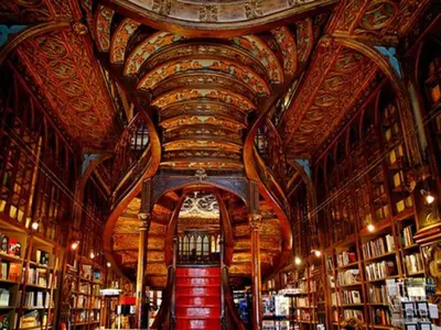 a library with a large ceiling with bookshelves at Pleasant apartment in Oporto in Porto
