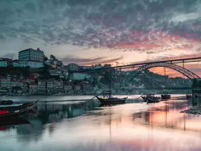 a bridge over a river with boats in the water at Charming urban apartment in Porto's heart in Porto