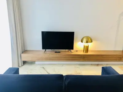 a living room with a tv and a blue couch at Bright and Spacious apartment in Porto in Porto