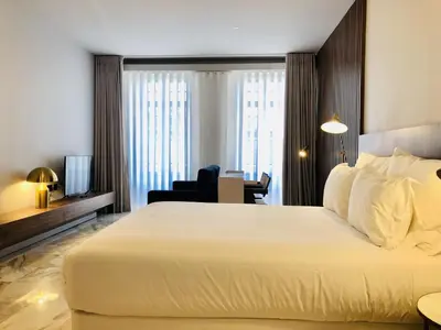 a hotel room with a large white bed and a desk at Bright and Spacious apartment in Porto in Porto