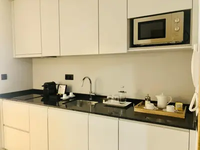 a kitchen with white cabinets and a microwave at Bright and Spacious apartment in Porto in Porto