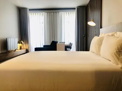 a bedroom with a large white bed and a chair at Bright and Spacious apartment in Porto in Porto