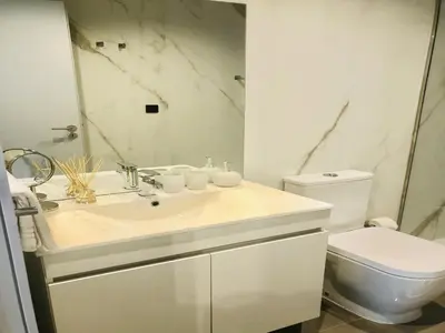 a bathroom with a white sink and a toilet at Bright and Spacious apartment in Porto in Porto