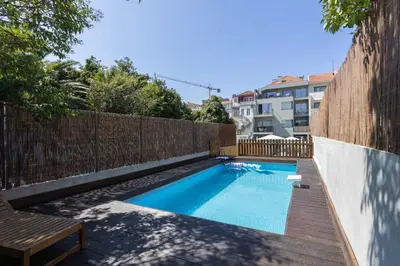 a swimming pool in a backyard with a wooden fence at Liiiving in Porto - Pool Paradise Apartments in Porto