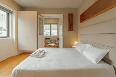 a bedroom with a large white bed and a table at Boutique Suites by Hosty in Porto