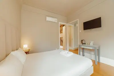 a bedroom with a white bed and a television at Boutique Suites by Hosty in Porto