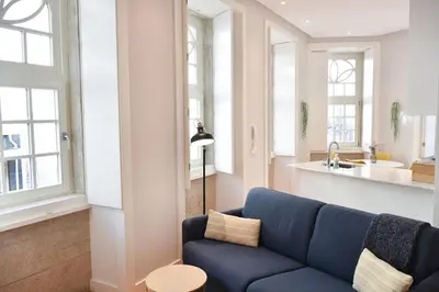 a living room with a blue couch and a kitchen at Central and comfortable apartment -downtown in Porto