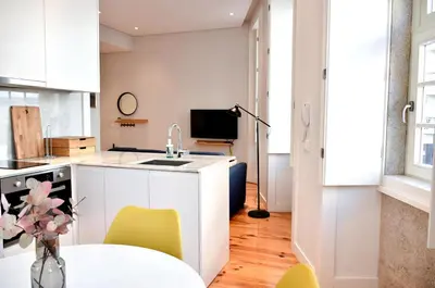 a kitchen with a sink and a table with yellow chairs at Central and comfortable apartment -downtown in Porto