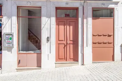 a facade of a building with red doors on it at Bright Flat few steps to Aliados Av by LovelyStay in Porto