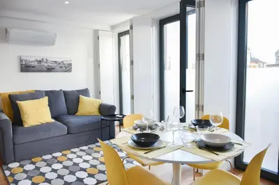 a living room with a table and a couch at Central with balcony - 9 min-walk to Trindade in Porto