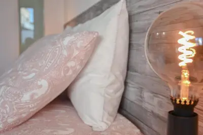 a lamp sitting next to two pillows on a bed at Central with balcony - 9 min-walk to Trindade in Porto