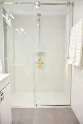a shower with a glass door in a bathroom at Central with balcony - 9 min-walk to Trindade in Porto