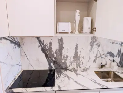a kitchen with a marble counter top and a sink at Downtown Studio 80 meters to metro and Free Parking in Porto
