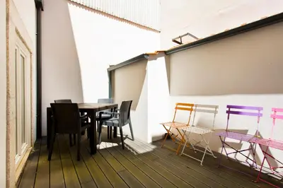 a room with a table and chairs on a balcony at Aposentus - Premium Central Apartment 1BR in Porto