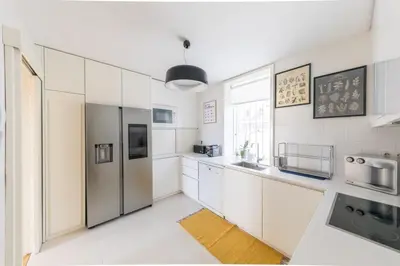 a kitchen with white cabinets and a stainless steel refrigerator at Casa Vista Douro in Vila Nova de Gaia