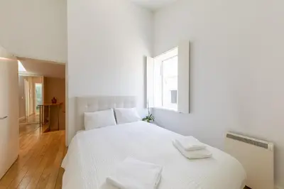 a white bedroom with a white bed and a window at Casa Vista Douro in Vila Nova de Gaia