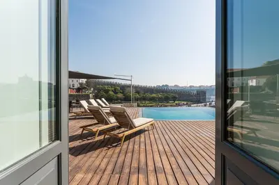 a deck with lounge chairs and a swimming pool at GuestReady - D. Hugo Boutique Hotel B&B in Porto