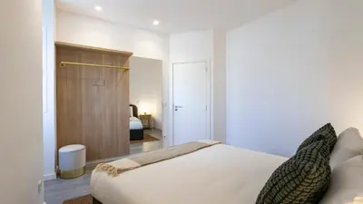 a bedroom with a bed and a room with a door at Bright 2BR Flat near Praça da Galiza by LovelyStay in Porto