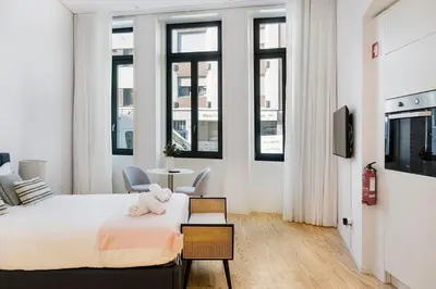 a bedroom with a bed and a table and some windows at Modern Studio in Porto Center, Ideal City Base in Porto