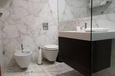 a white bathroom with a toilet and a sink at Refúgio Douro à Vista in Porto
