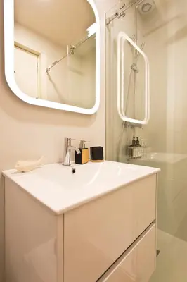 a white bathroom with a sink and a mirror at Gabi's House in Porto