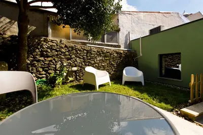 a patio with two chairs and a glass table at Gabi's House in Porto