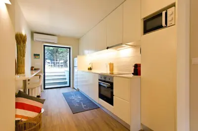 a kitchen with white cabinets and a stove top oven at Gabi's House in Porto